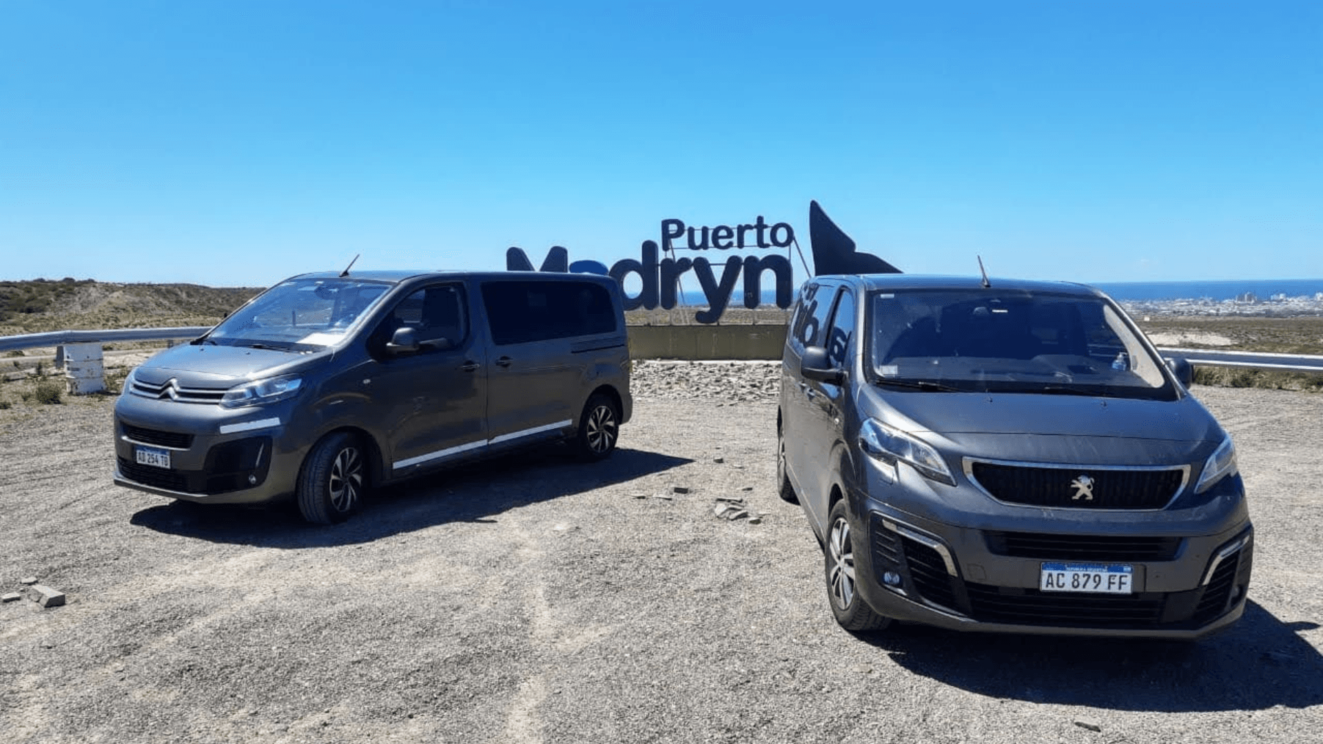 Vehículos VS Transfers con letrero Puerto Madryn